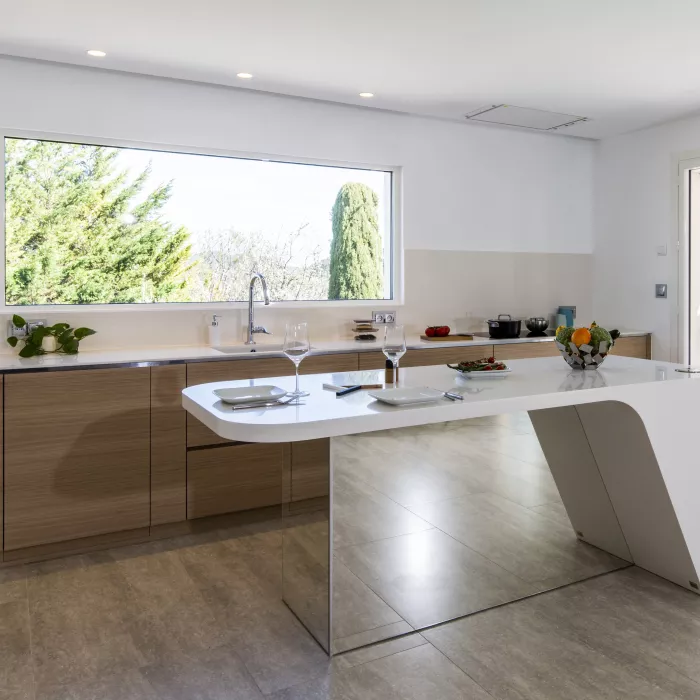 A contemporary, light-filled HIMACS kitchen with a mountain view